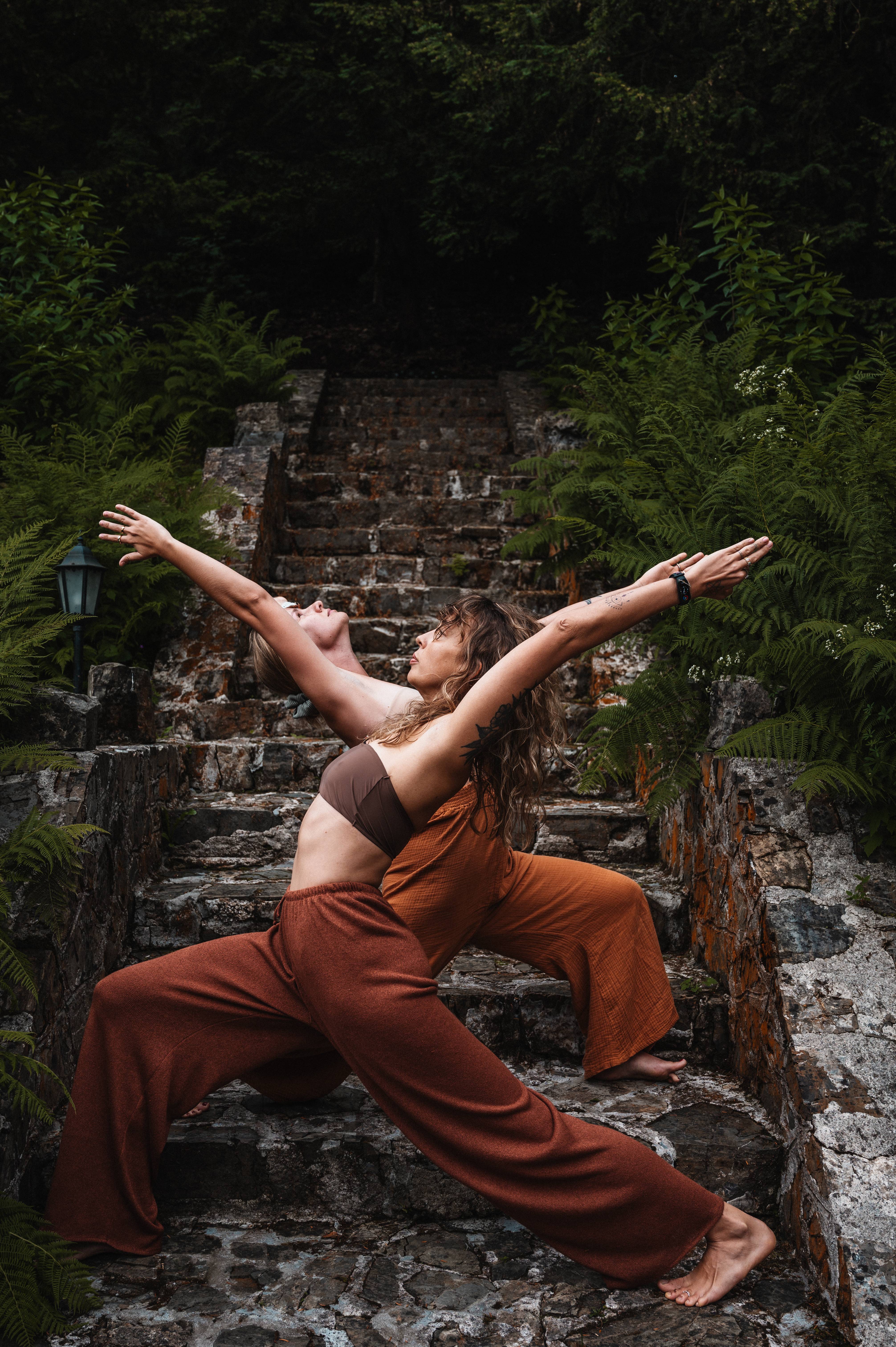 Agnieszka i Marcela w pozycji jogi, na tle schodów i zieleni.